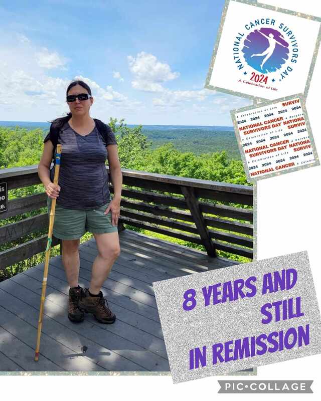 A woman stands on a lookout deck in outdoor attire, holding a walking stick and smiling. The scene emphasizes her achievement of 8 years in remission, celebrating National Cancer Survivors Day 2024.