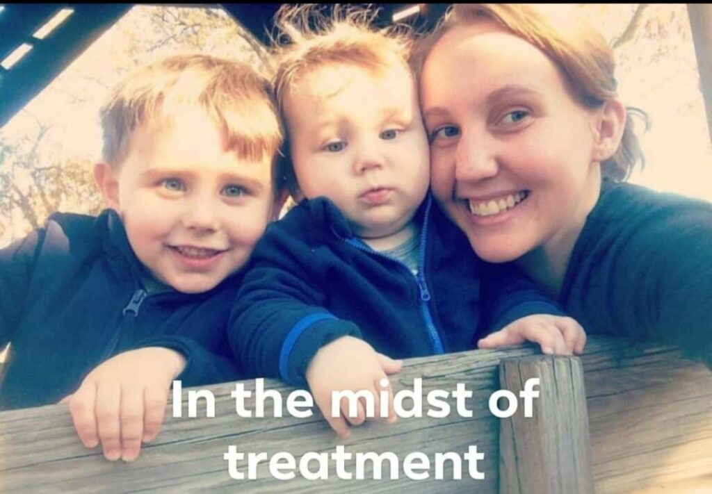 A woman smiles with two children at a playground, conveying joy and resilience during a challenging time, highlighted by the text, "In the midst of treatment."